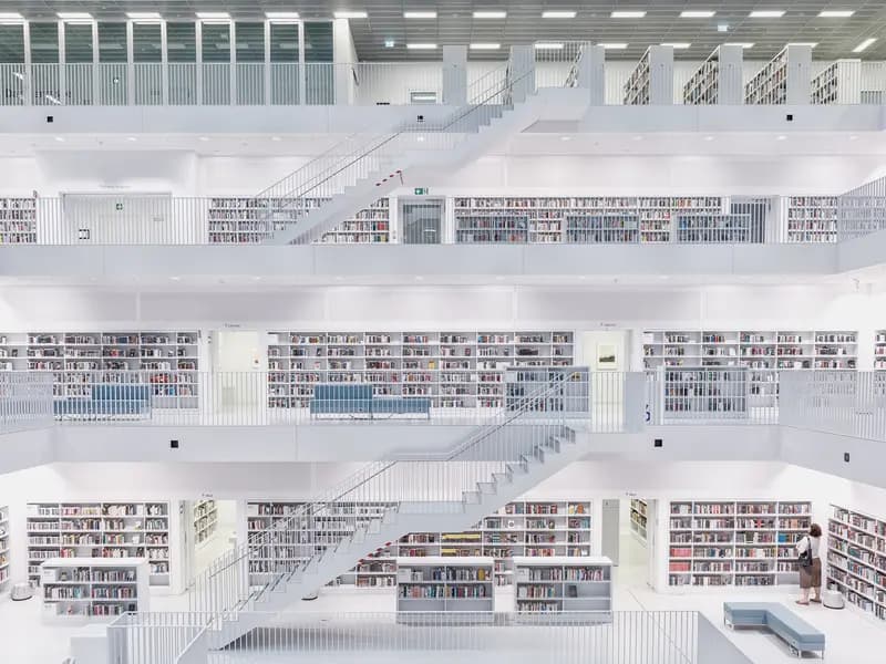 Helle, moderne Bibliothek mit weißen Galerien, Treppen und Bücherregalen