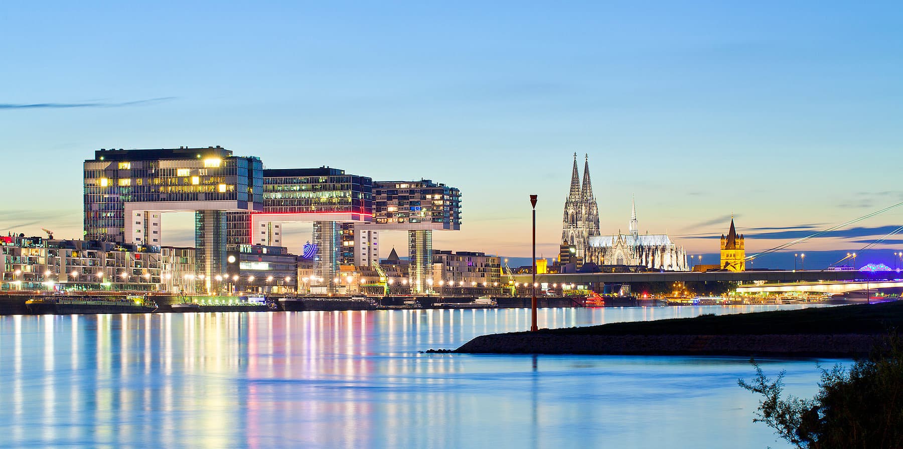 Kranhäuser und Kölner Dom am Rhein im Abendlicht