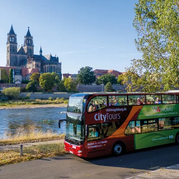 Stadtrundfahrt-Bus an der Elbe, im Hintergrund der Magdeburger Dom