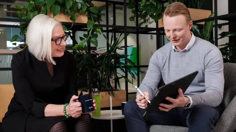 Beraterin und Berater im Gespräch an einem Tablet